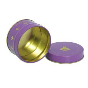 Liten rund blikkboks med gull inne